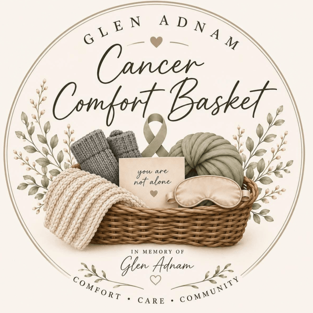 A circular graphic depicting a 'Cancer Comfort Basket' filled with cozy items like knitted accessories, a sleep mask, and a comforting note that says 'you are not alone,' surrounded by decorative leaves and the text 'in memory of Glen Adnam.'