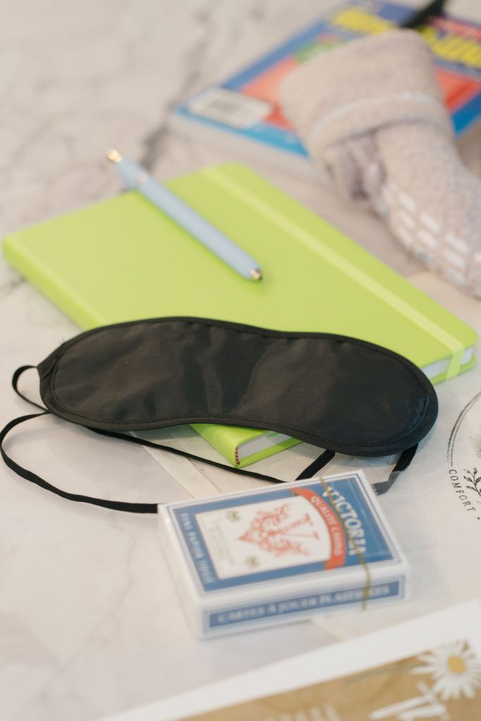 The branded tote bag open, with a cozy teal blanket visible inside alongside other care items